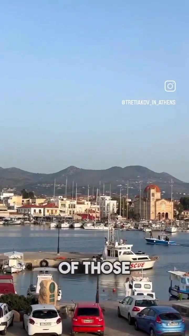 Aegina harbour with boats and yellow church